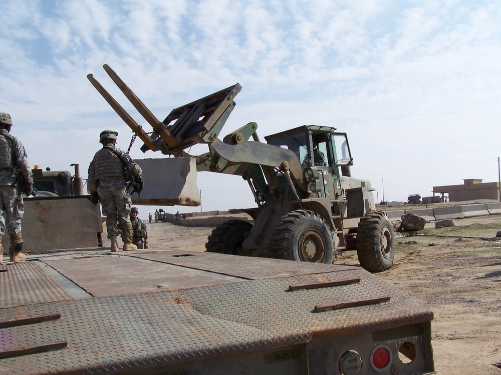 Soldiers load concrete barriers