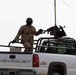 An Iraqi Soldier provides security for others as they procure concrete barr