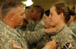 Gen. Cody pins the Combat Action Badge on Spc. Masser