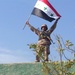 An Iraqi Soldier displays his country's flag