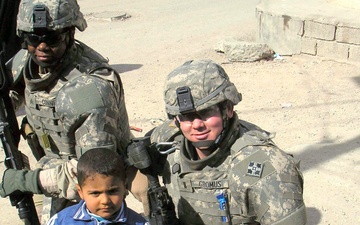 1st Lt. Gromus and Sgt. Conner Pose With an Iraqi Boy