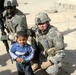 1st Lt. Gromus and Sgt. Conner Pose With an Iraqi Boy