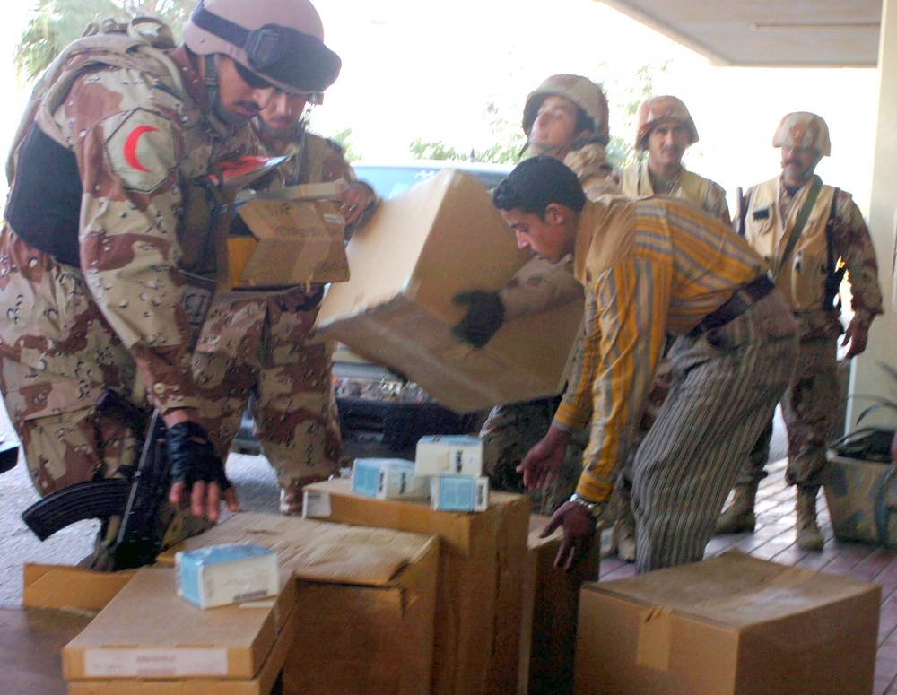 Iraqi Army Soldiers and hospital personnel unload medical supplies