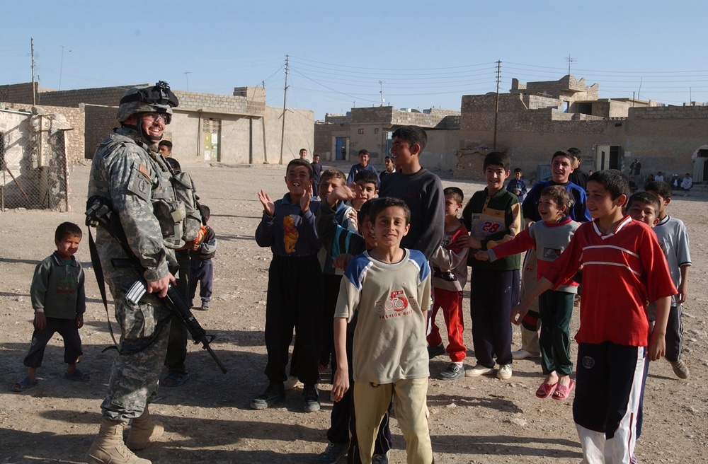 Soldiers hand out soccer balls in Tal Afar