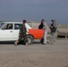 Pfc. Clinton Roberts and Iraqi soldiers inspect a vehicle