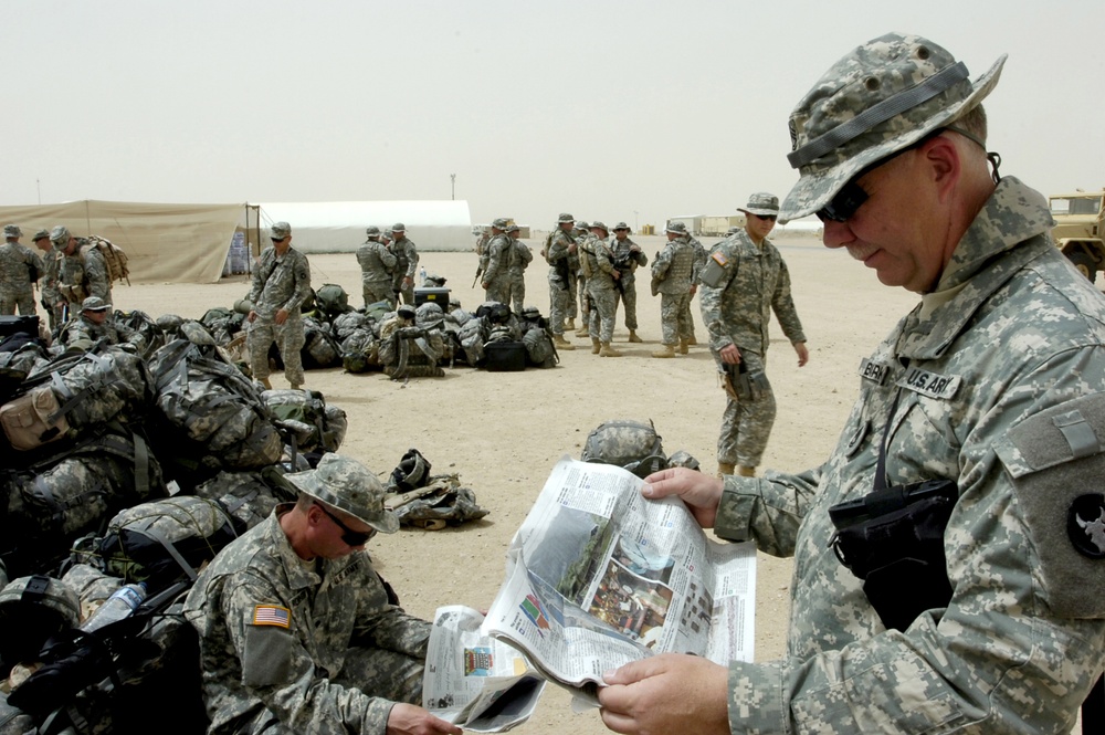 Sgt. 1st Class Birkman reads a Stars and Stripes