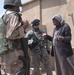Iraqi Army soldiers and coalition forces speak to a farmer in Ma