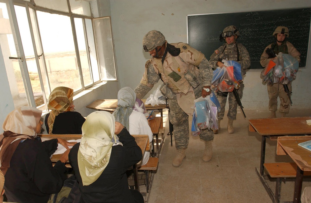Staff Sgt. Washington hands out bags of school supplies
