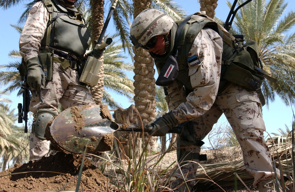 Estonian Soldier Digs a Hole to Look for Weapons