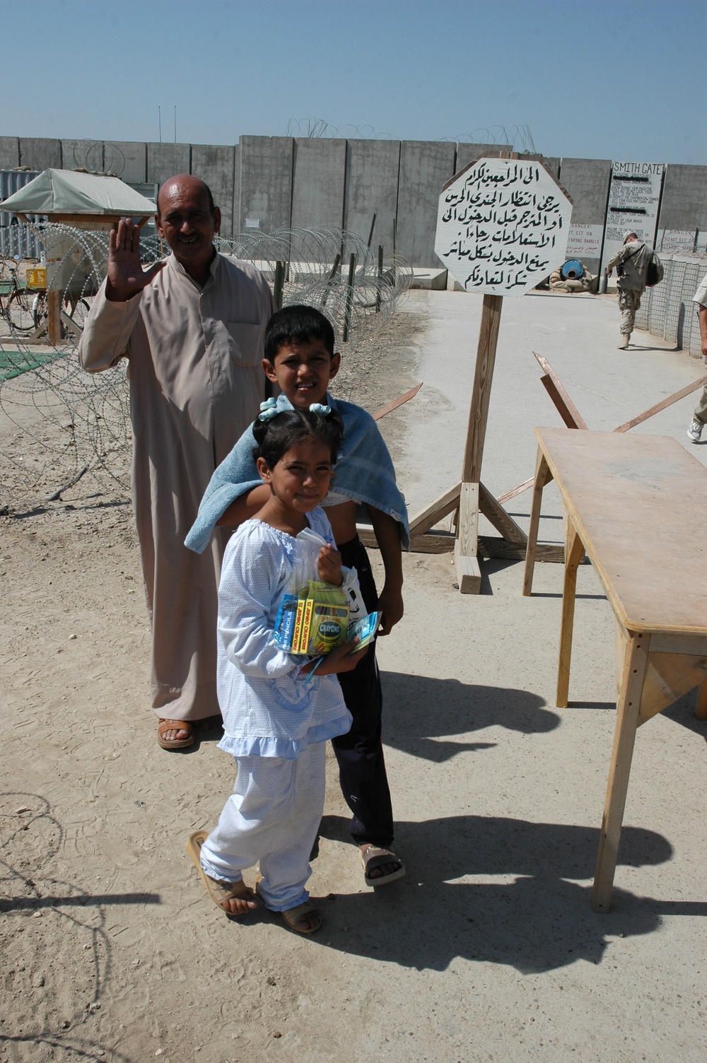 A Iraqi man and his children wave