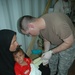 Sgt. Marti changes the bandages on a 15-month old Iraqi girl's arm