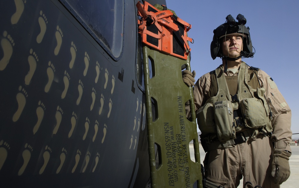 Technical Sgt. De Corte stands next to a HH-60 Pavehawk helicopter