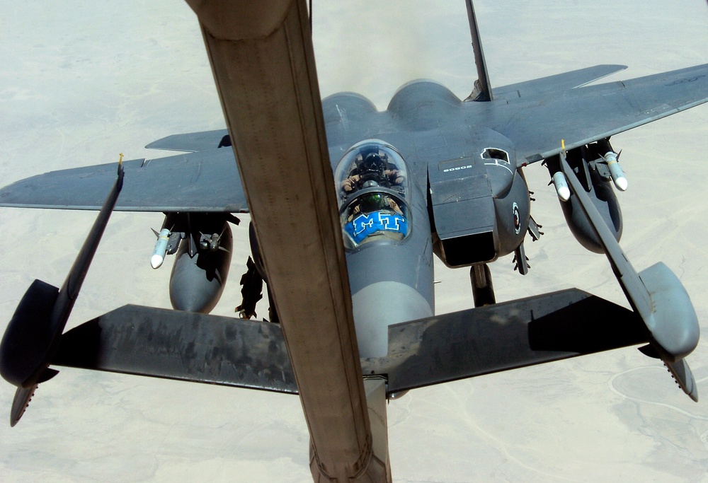 An F-15 Strike Eagle pulls up to the refueling boom of a KC-10 Extender