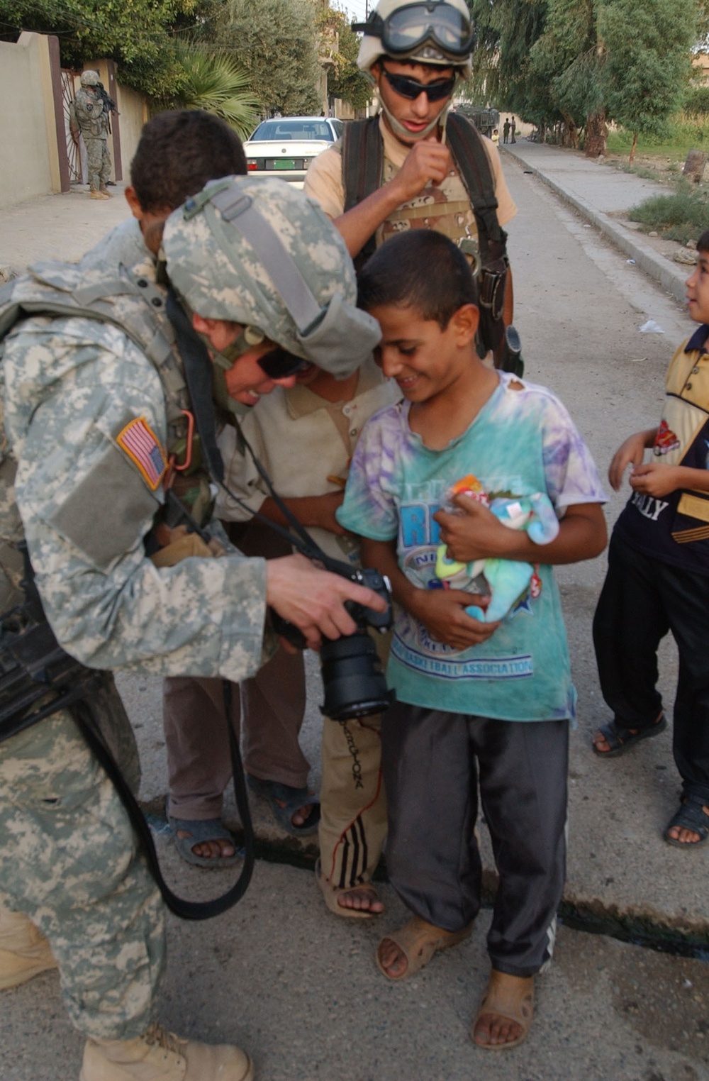 Pfc. Poulin shows a few Iraqi children their pictures in her camera