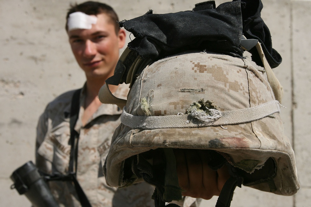 Hard-headed Marine walks away from shot to helmet