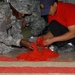 BALAD, Iraq (Nov. 11, 2006) - Spc. Benita Barnes, a cook with the 368th Cargo Transportation Company out of Ft. Story, Va., and a civilian contractor add red food coloring to white rice. The rice was then used to create a large American flag and was sprea