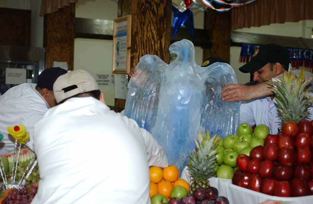 Workers at DFAC 3 place their eagle ice sculpture in the center of the fruit arrangement for the Veterans Day competition. DFAC 3 won first place in the small dining facility category.