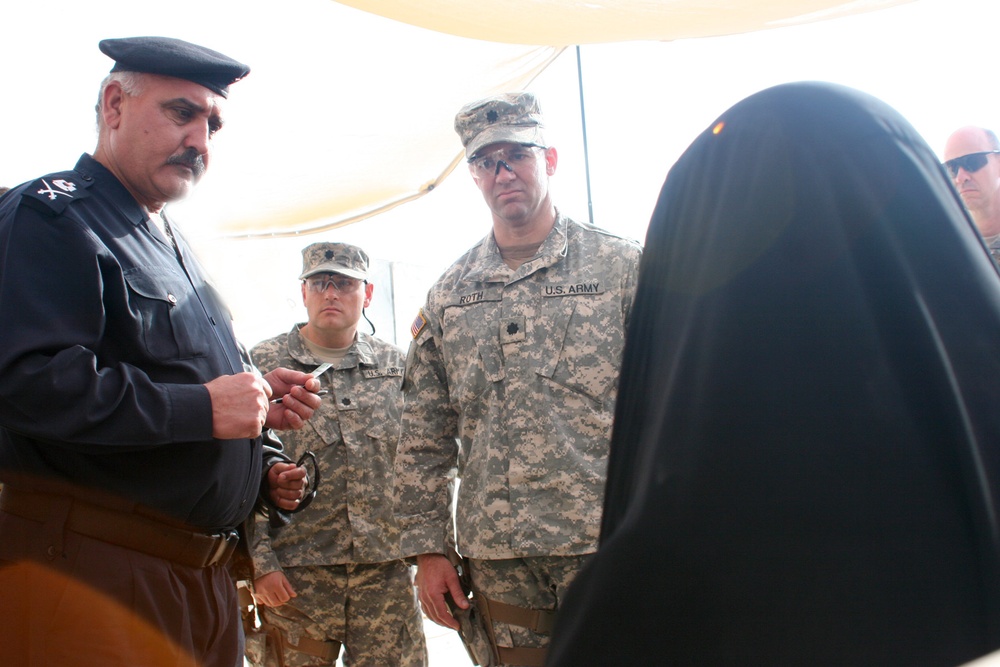 Iraqi Police take female detainee into custody from coalition forces