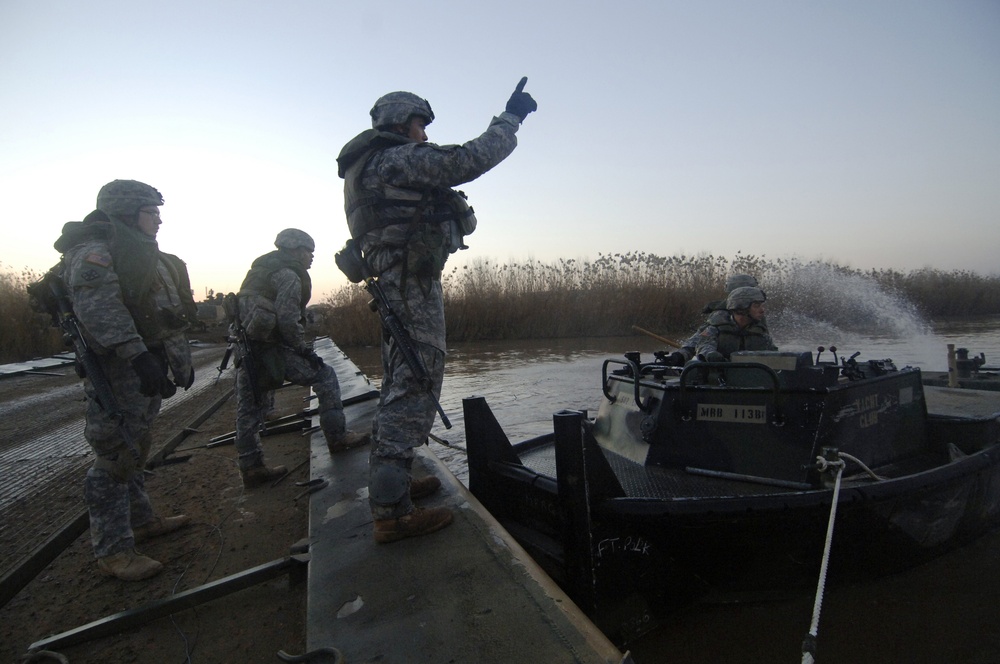 Soldiers build an assault, float bridge outside Camp Taji