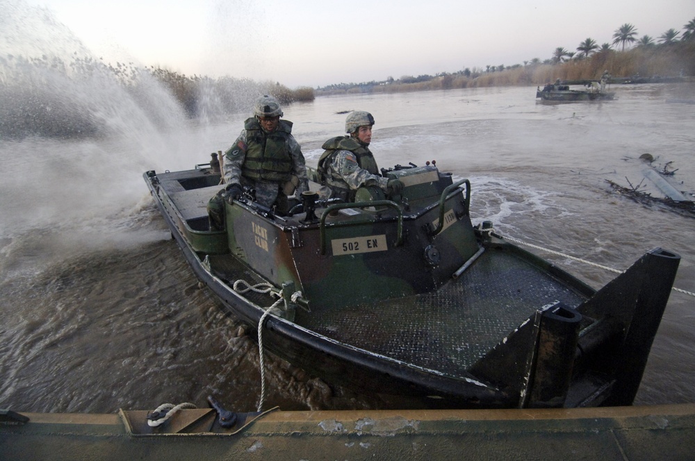 Soldiers build an assault, float bridge outside Camp Taji