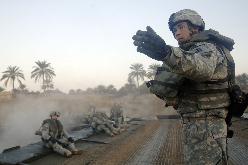 Soldiers build an assault, float bridge outside Camp Taji