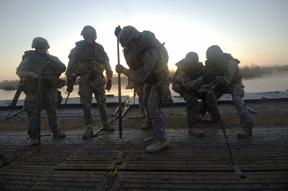 Soldiers build an assault, float bridge outside Camp Taji