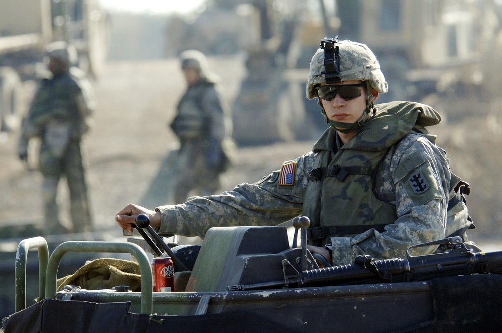 Soldiers build an assault, float bridge outside Camp Taji