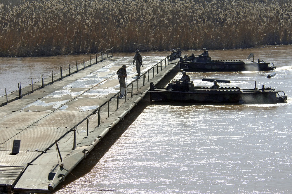 Soldiers build an assault, float bridge outside Camp Taji