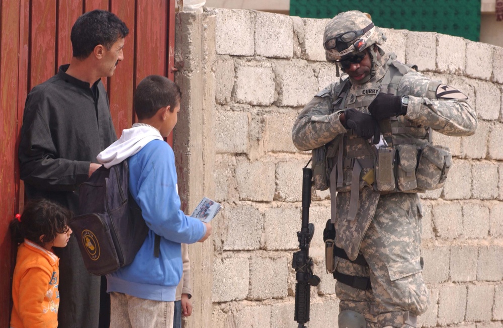 U.S. Soldier hands out flyers in Mosul