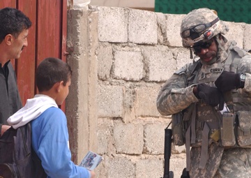 U.S. Soldier hands out flyers in Mosul