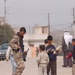 Iraqi soldier talks with children in Mosul