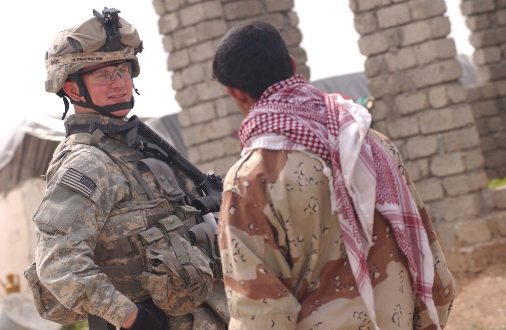 U.S. Army Soldier, Iraqi police talk during patrol in Mosul