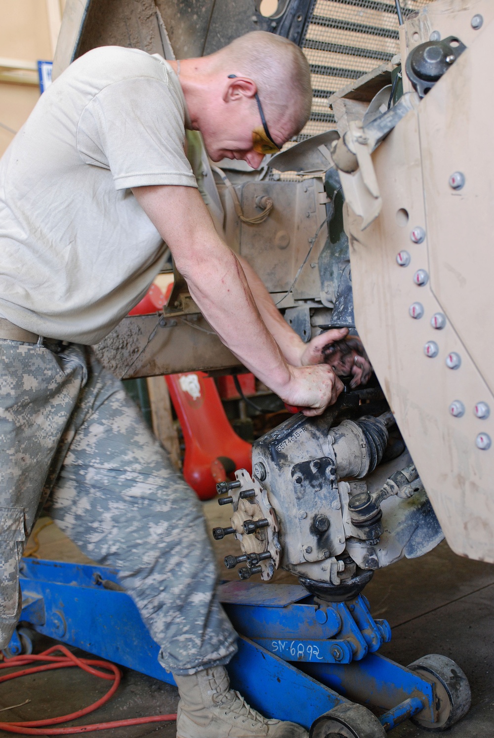 Army mechanics work on up-armored Humvee