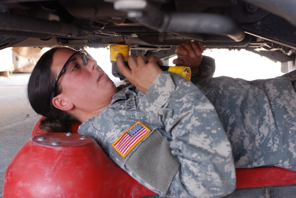 Female Soldier checks for oil leaks