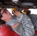 Female Soldier checks for oil leaks