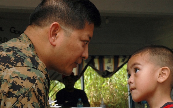 Capt. Yves Nepomuceno helps a Micronesian boy during medical civic action p