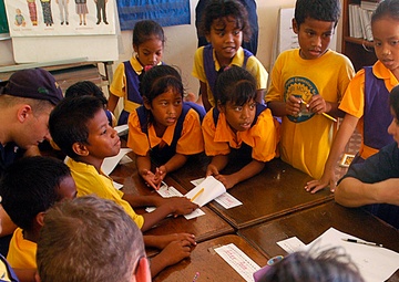 Sailors interact with students at elementary school