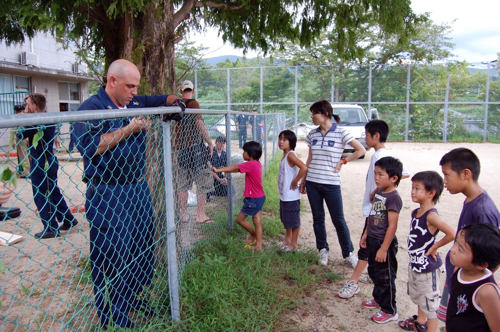 Japanese Children watch as sailors repair Tenshin-ryo Children's hom