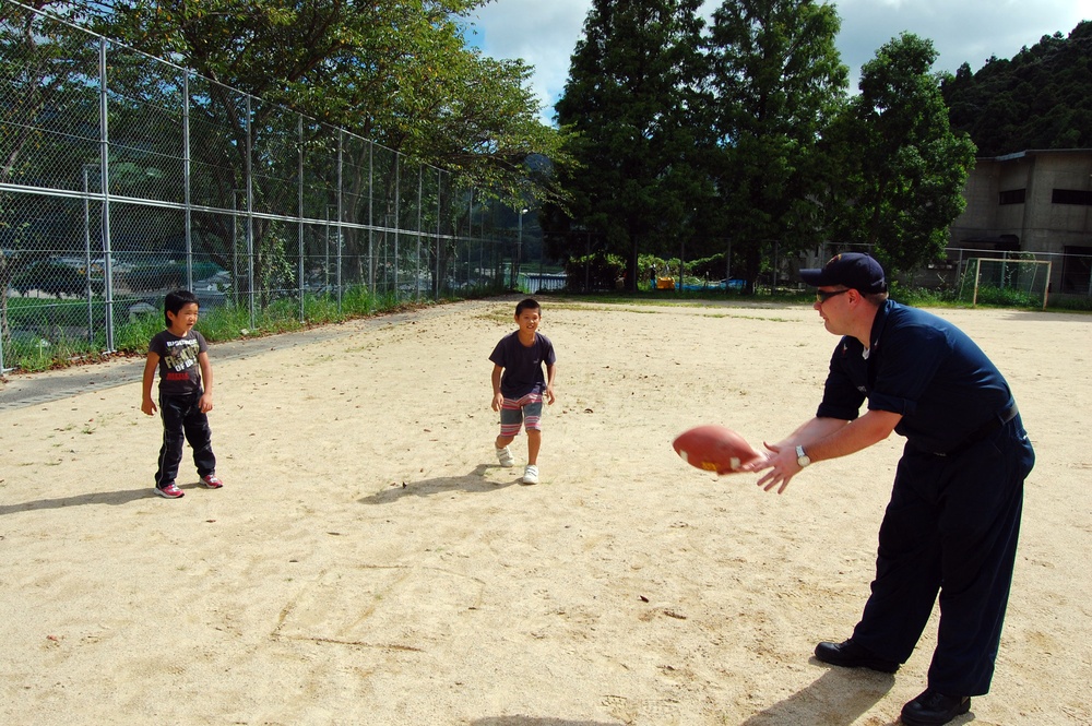 Sailors play catch with Japanese children