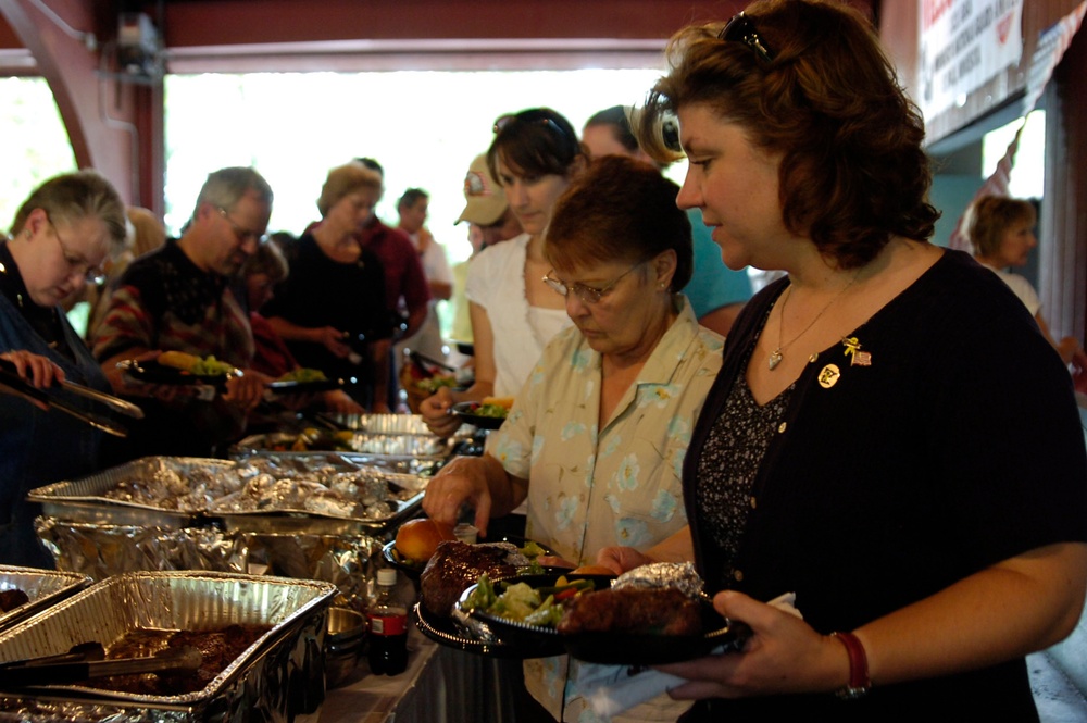 Family, friends, and soldiers enjoy a grilled meal