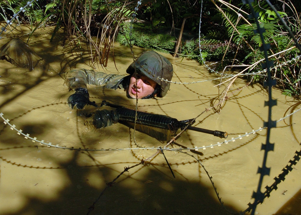 Petty Officer traverses mud-filled trench