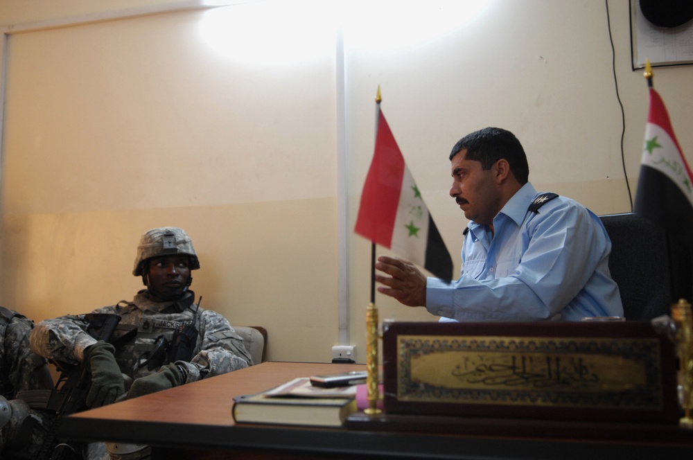 U.S. Army Sgt. Talks With Assistant Iraqi Police Commander