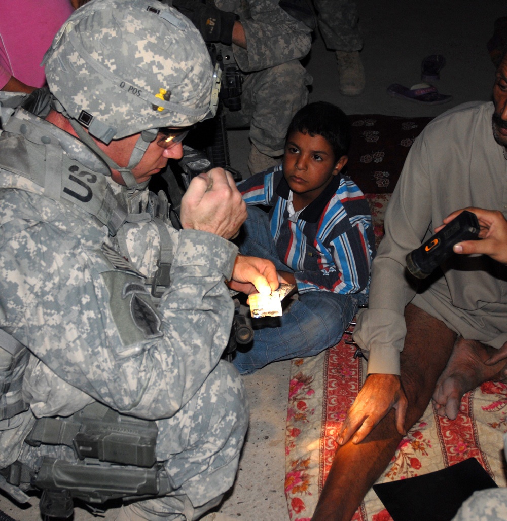 Cavalry Soldiers provide aid to injured Iraqi man injured during insurgent