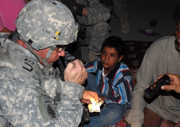 Cavalry Soldiers provide aid to injured Iraqi man injured during insurgent
