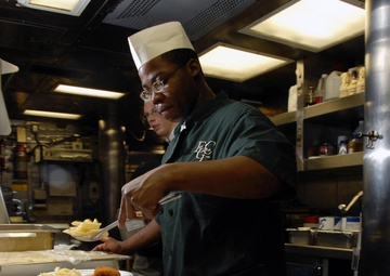 Seaman prepares crab cakes