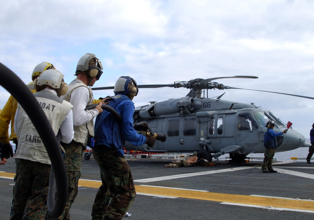 Flight deck firefighters attack a simulated fire on USS Tarawa