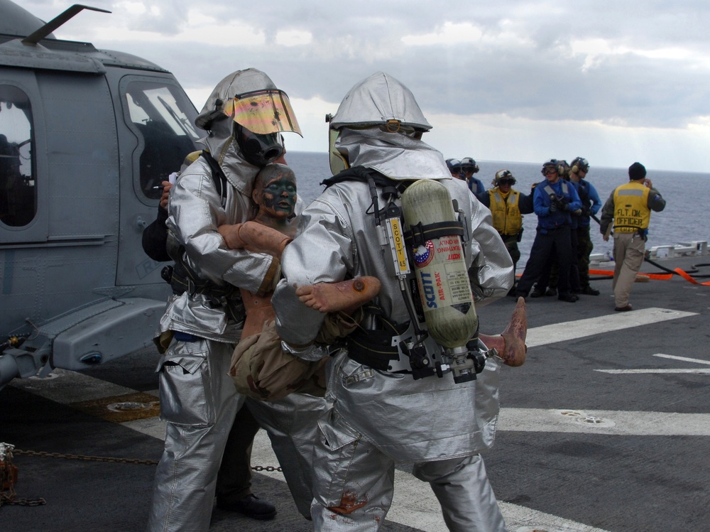 Flight deck firefighters attack a simulated fire on USS Tarawa