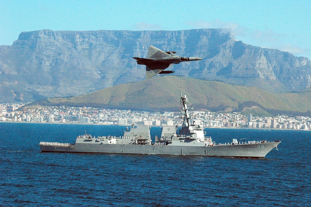 South African Air Force Cheetah fighter jet flies over USS Forrest Sherman