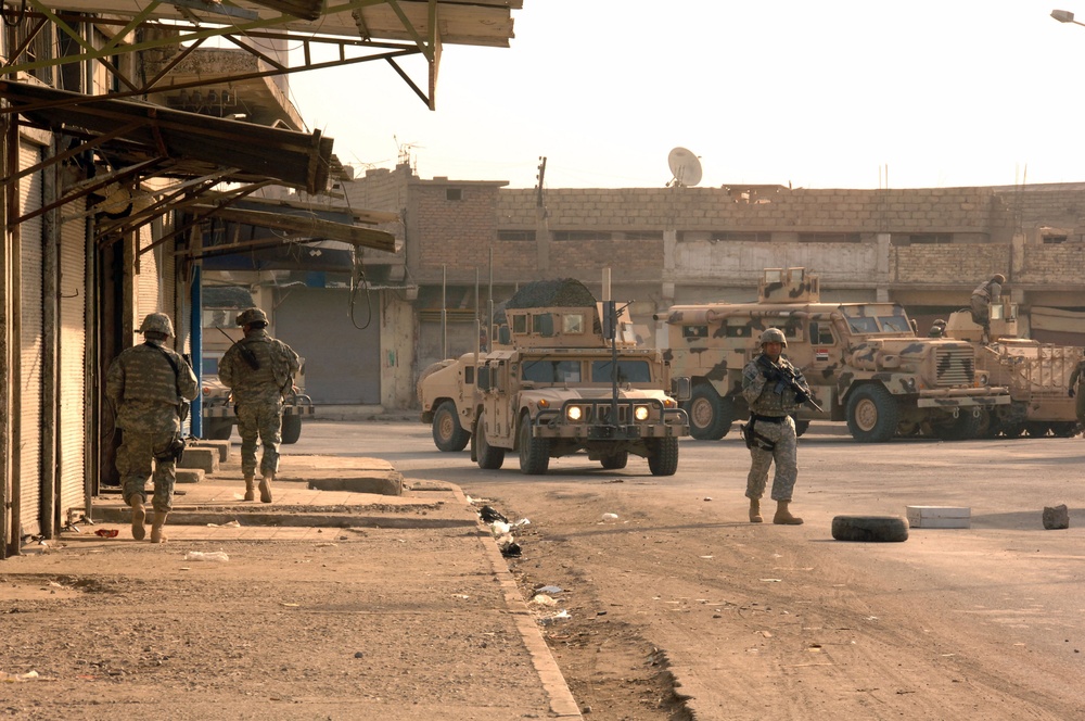 U.S. Army and Iraqi soldiers patrol side by side