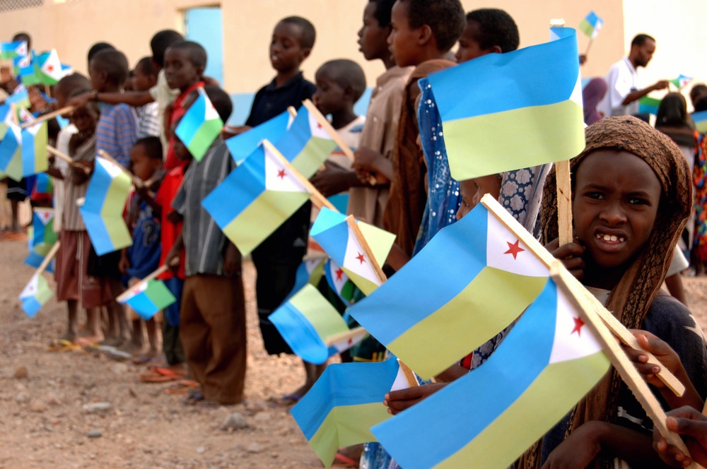 Children wave flags prior to dedication ceremony